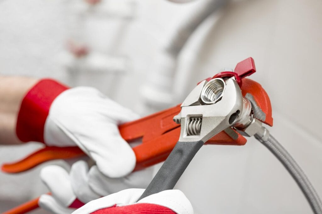 Plumber holding pipe wrenches for an emergency repair in Aurora