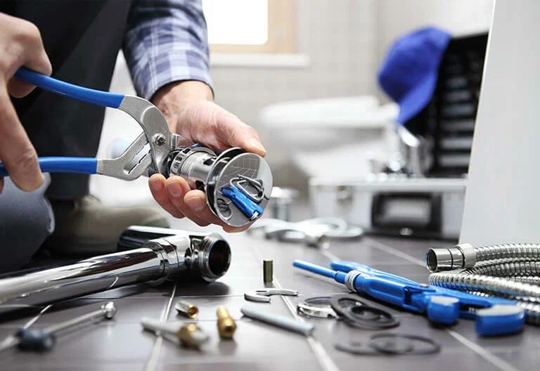 Technician repairing a plumbing fixture with professional tools in Aurora