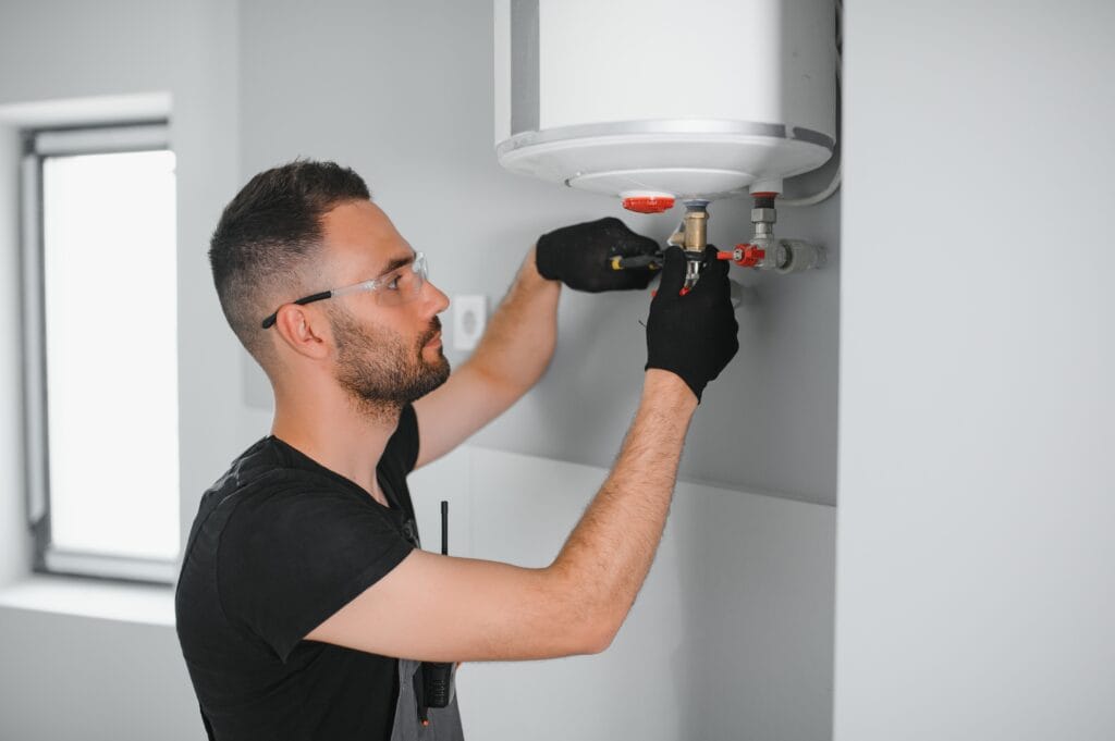 Technician performing water heater maintenance in Aurora