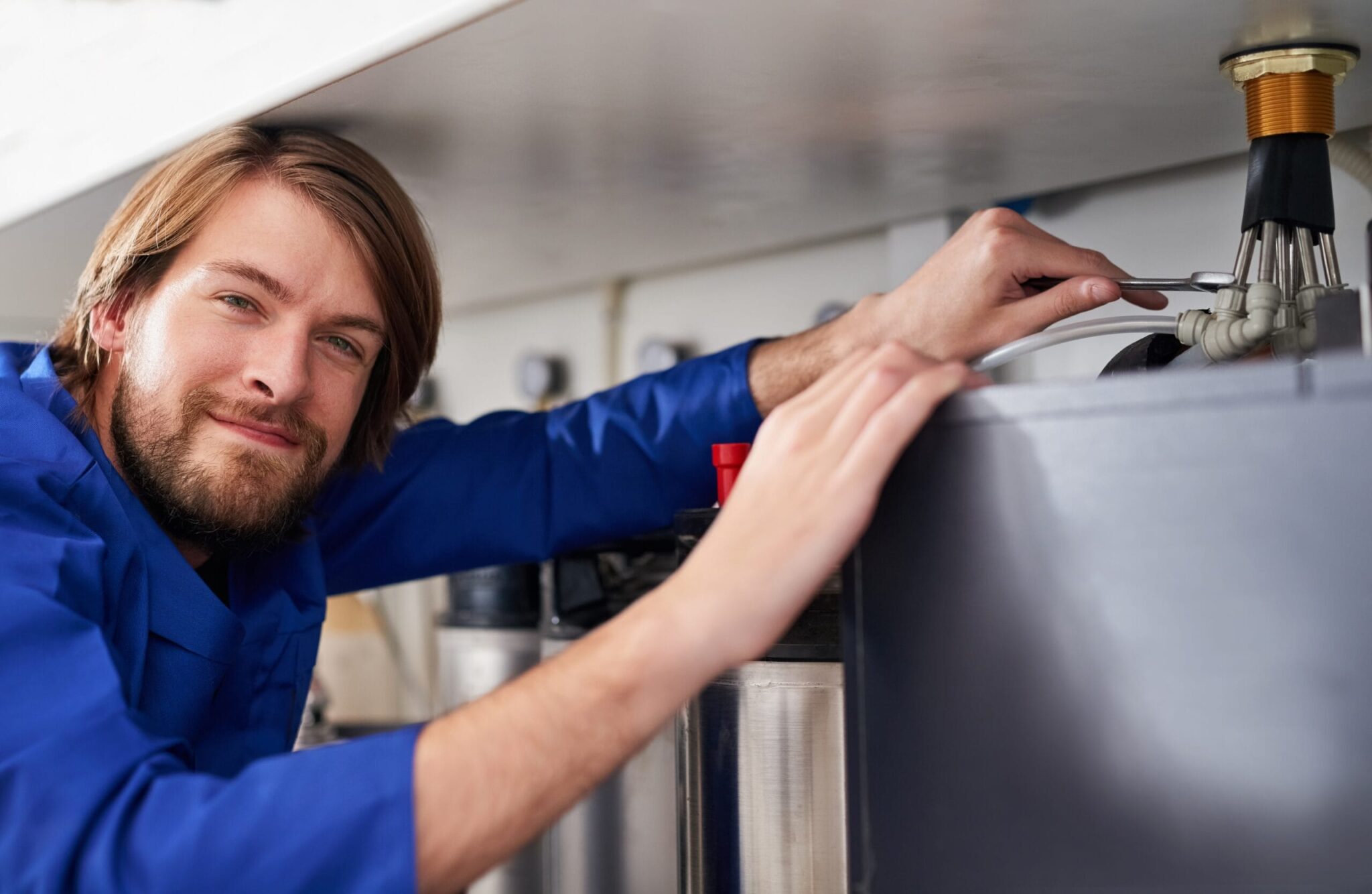Technician servicing a residential water heater tank in Aurora