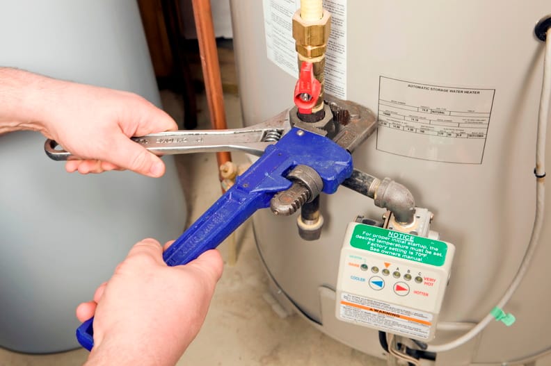 Plumber repairing a water heater valve in Aurora